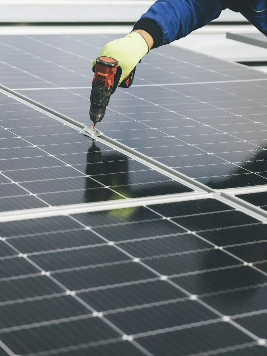 Technician fastening a solar panel during a service visit