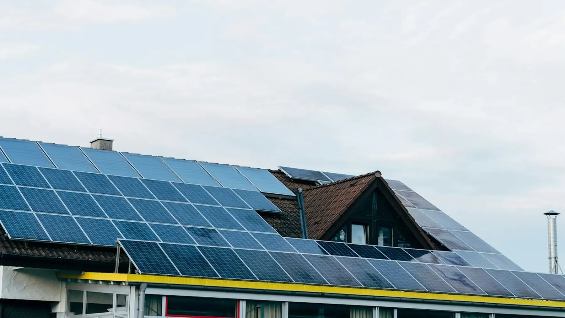 A long residential roofline covered end to end with solar panels